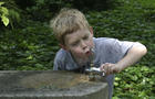 boy drinking from water fountain 