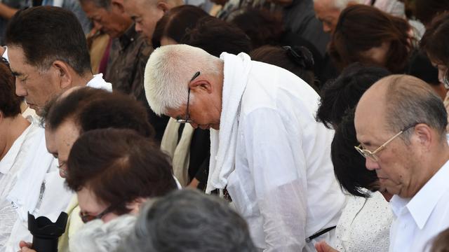 People offer silent prayers during a memorial service for those who died in the Battle of Okinawa during World War II at the Peace Memorial Park in Itoman, in Japan's southern island of Okinawa prefecture 