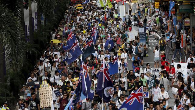 Protesters carry Hong Kong colonial flags during a march for democracy in Hong Kong, China 