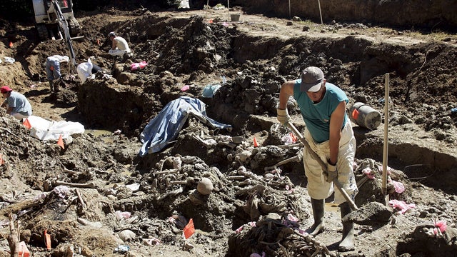 Forensic experts search for remains during an exhumation at a mass grave at Budak, near Srebrenica 