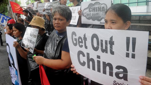 Protesters display placards during a rally in front of the Chinese Consulate in Manila's financial district on July 10, 2015, calling to boycott products made in China and denouncing China's claim to most of the South China Sea including areas claimed by  