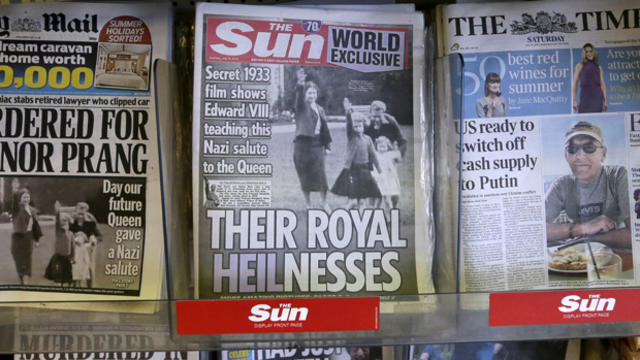 A row of newspapers on display, including a paper with a photo of Britain's Queen Elizabeth II as a child giving a Nazi salute, are seen in a shop in London July 18, 2015. 