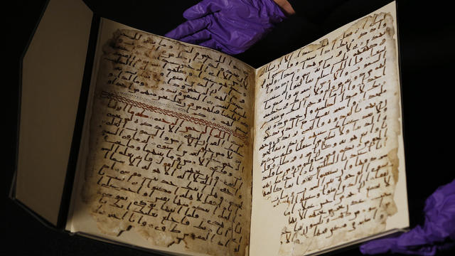 A university assistant shows fragments of an old Quran at the University in Birmingham, in Birmingham central England 