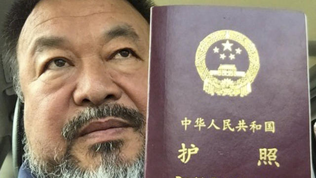 Chinese dissident artist Ai Weiwei poses with his passport in Beijing in this handout picture 