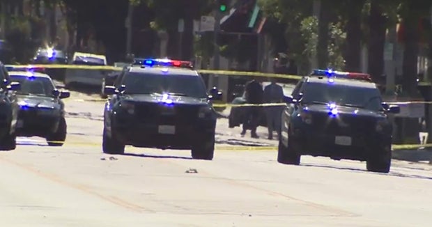 Los Angeles police shoot armed suspect on busy street - CBS News
