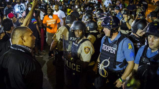 St. Louis County police officers interact with anti-police demonstrators during protests in Ferguson, Missouri, Aug. 10, 2015. 