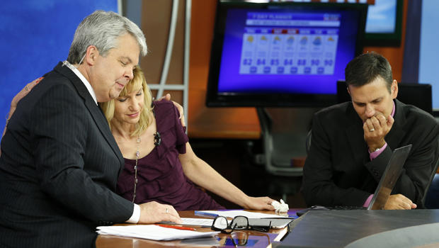 WDBJ-TV7 news morning anchor Kimberly McBroom, center, gets a hug from visiting anchor Steve Grant, left, as meteorologist Leo Hirsbrunner reflects after their early morning newscast at the station Aug. 27, 2015, in Roanoke, Va. 