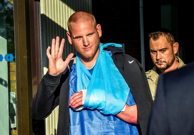 Off-duty U.S. Air Force Airman Spencer Stone, left, one of the men to overpower the gunman who opened fire with an assault rifle on a high-speed train, gestures as he leaves the hospital in Lesquin, northern France, Aug. 22, 2015. 