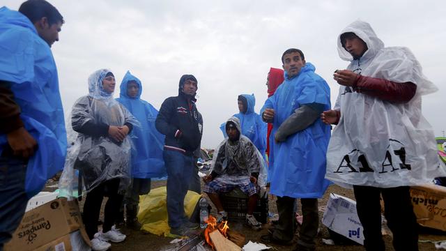 Migrants rest in rain covers at a collection point in Roszke, Hungar 