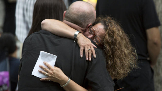 People embrace during a ceremony marking the 14th anniversary of the 9/11 attacks at the National September 11 Memorial and Museum in Lower Manhattan in New York Sept. 11, 2015. 