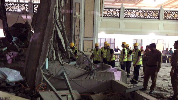 In this image released by the Saudi Interior Ministry's General Directorate of Civil Defense, Civil Defense personnel inspect the damage at the Grand Mosque in Mecca after a crane collapsed, killing dozens, Sept. 11, 2015.