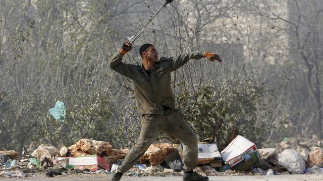 A Palestinian uses a sling to hurl stones towards Israeli troops during clashes in the West Bank village of Beit Ommar, north of Hebron November 3, 2015.  