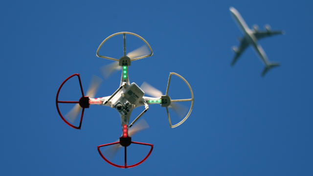 A drone is flown for recreational purposes as an airplane passes nearby in the sky above Old Bethpage, New York, Sept. 5, 2015. 