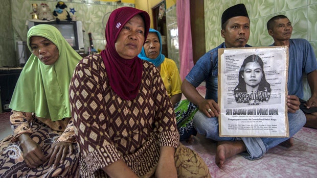 Family members of beheaded Indonesian maid Siti Zainab display a poster bearing her portrait at their family home in Bangkalan, Indonesia, April 15, 2015. Saudi authorities said she was executed a day earlier in the Muslim holy city of Medina after being  