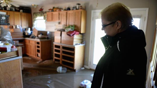 Emma Smith takes in the damage of her home after floodwaters recede on Jan. 1, 2016, in Pacific, Missouri. 