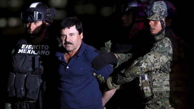 Joaquin "El Chapo" Guzman is escorted by soldiers during a presentation at the hangar belonging to the office of the attorney general in Mexico City, Mexico, Jan. 8, 2016. 