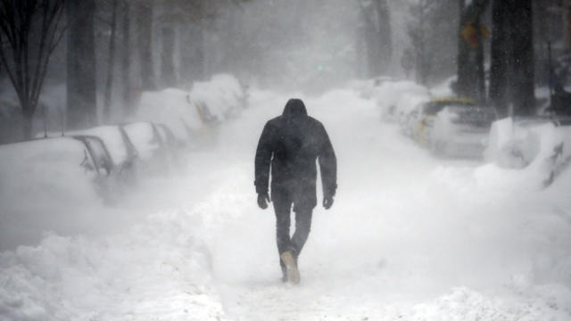 A man walks along a street covered by snow during a winter storm in Washington Jan. 23, 2016. 