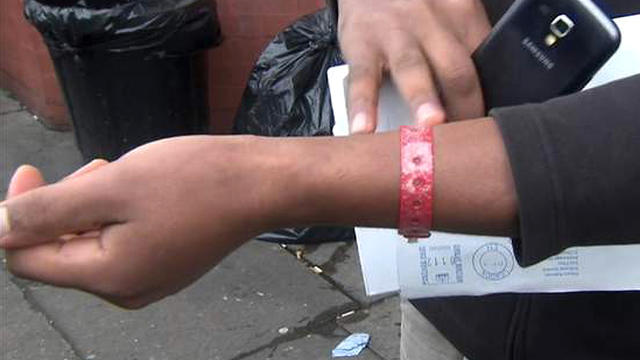 ​A screengrab shows an asylum-seeker in Cardiff, Wales showing the camera his red wristband, which he was told to wear by a government contractor providing food and housing for refugees 