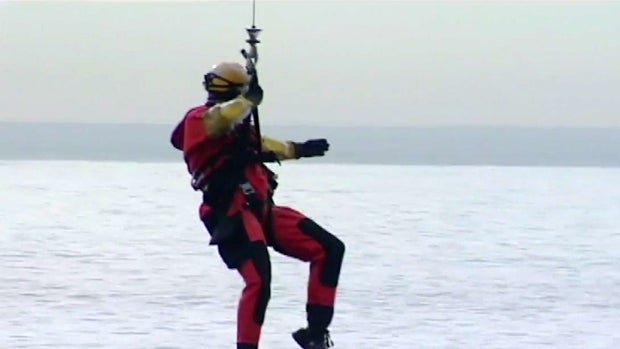 ​A U.S. Coast Guard rescue swimmer is lowered into the Pacific Ocean after a man was swept away from a beach in Pacifica, California, Feb. 9, 2016. 