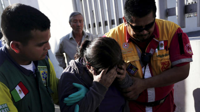 ​An inmate's family member is helped by a Green Cross worker and a Civil Protection worker outside the Topo Chico prison in Monterrey, Mexico, Feb. 11, 2016. 