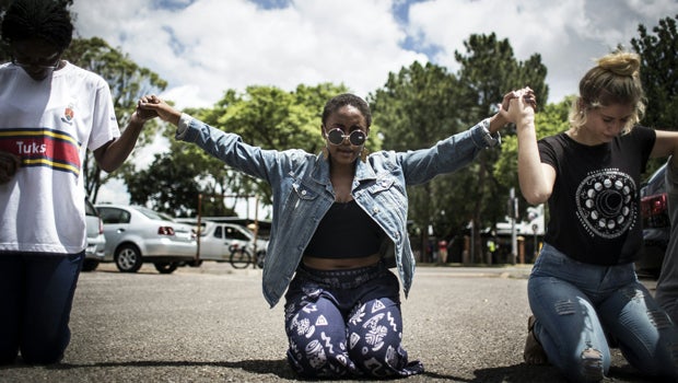 Student members of the Christian Revival Church pray for peace as a protest against the scrapping of the Afrikaans language at the University Of Pretoria as a medium of instruction got violent in Pretoria, South Africa, on Feb. 23, 2016. 