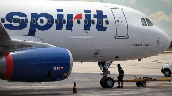 A Spirit Airlines Inc. employee walks under a plane on the tarmac at the Fort Lauderdale International Airport after striking pilots agreed to a new contract June 17, 2010, in Fort Lauderdale, Florida. 