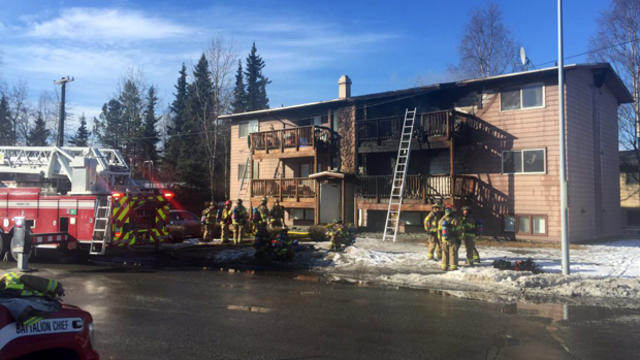 ​Crews work the scene after a fire at an apartment building in Anchorage, Alaska, on March 23, 2016. 