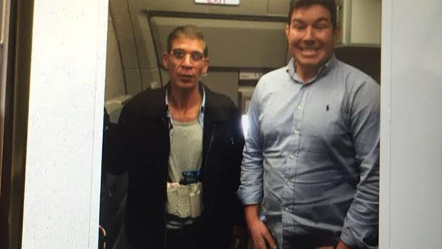 ​A photo taken aboard hijacked EgyptAir flight 181, March 30, 2016, shows hijacking suspect Seif Eddin Mustafa, wearing what turned out to be a fake suicide vest, with Ben Innes of Britain 