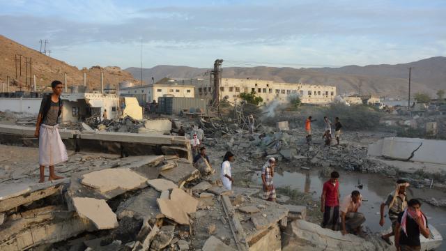 People inspect damage at a site hit by Saudi-led airstrikes in the al Qaeda-held port city of Mukalla in southern Yemen 