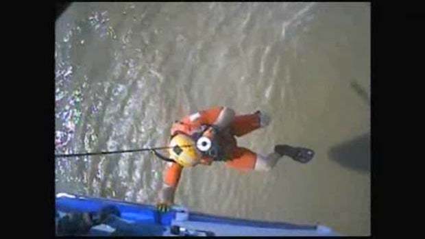A U.S. Coast Guard crew member descends from a helicopter to rescue one of two boaters who had been missing for two days April 27, 2016.​ 