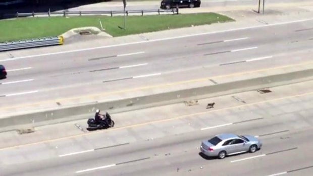 Officer James Shiderly of the Fort Worth, Texas, police pursues a dog on Interstate 30 May 4, 2016, in this screen capture of a cellphone video obtained by CBS station KTVT. 