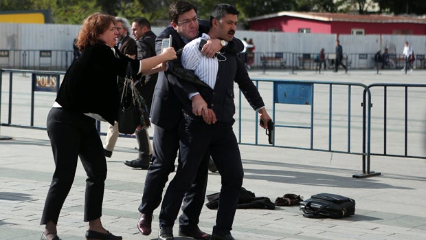 An assailant who attempted to shoot prominent Turkish journalist Can Dundar is caught by Dilek Dundar, wife of Can Dundar, and an opposition party legislator outside a courthouse in Istanbul, Turkey, May 6, 2016. 