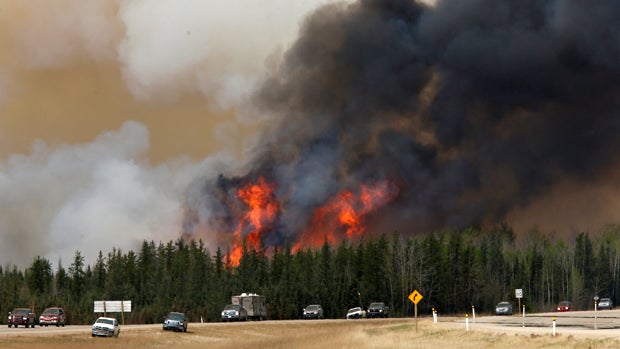 ​A wildfire burns as evacuees who were stranded north of Fort McMurray, Alberta, Canada, head south of the city on Highway 63, May 6, 2016. 
