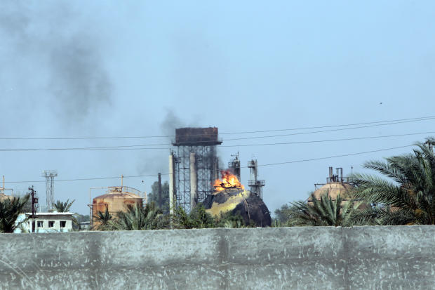 Flames and smoke rise from tanks after an ISIS suicide bomb attack on the Taji gas plant, about 12 miles north of the Iraqi capital Baghdad 