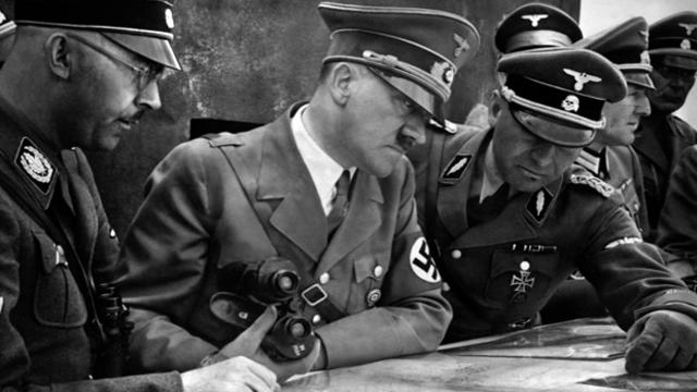 A picture from 1939 shows German Nazi Chancellor and dictator Adolf Hitler, center, consulting a geographical survey map with his general staff, including Heinrich Himmler, left, and Martin Bormann, right, during World War II. 