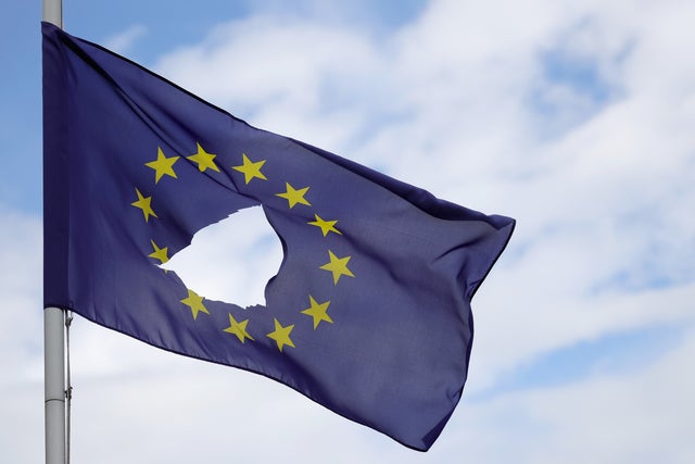 A European Union flag, with a hole cut in the middle, flies at half-mast outside a home in Knutsford Cheshire, England, after the United Kingdom's historic referendum to leave the EU on June 24, 2016.