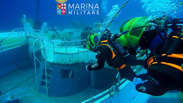 ​An image released by Italy's navy on June 29, 2016, shows navy divers working around a sunken migrant ship that capsized 