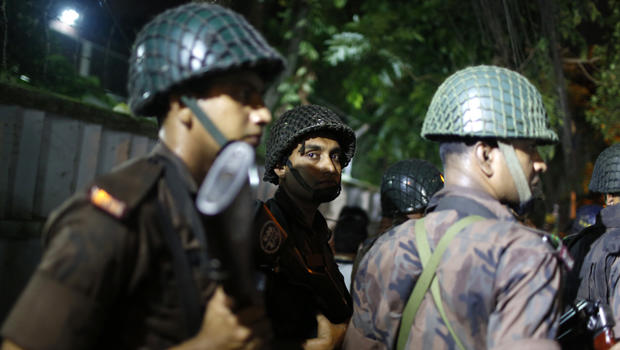 Bangladeshi security personnel stand guard near a restaurant that was attacked by gunmen in Dhaka, Bangladesh, on July 1, 2016. 