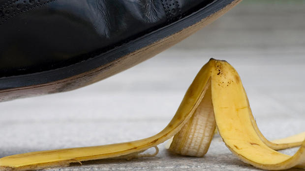 Businessman about to slip on a banana skin 