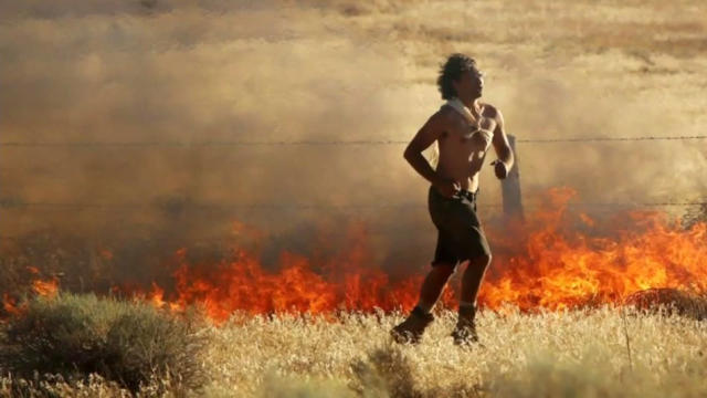 An arson suspect, identified by authorities as David Artiaga, 27, runs from a fire in Neenach, California, on July 20, 2016, in this image provided to CBS Los Angeles by Bernie Deyo. 