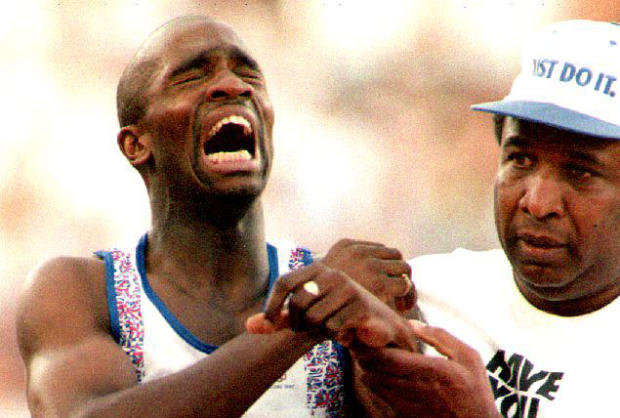 ​Derek Redmond, left, of Great Britain is helped by his father Aug. 3, 1992, in Barcelona, Spain, after suffering a torn hamstring during a second-round heat of the men's 400-meter run at the 1992 Summer Olympics. 