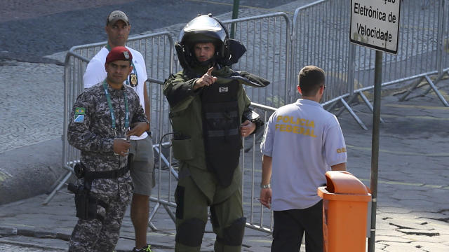 An agent of the bomb squad in protective clothing stands in the area near the finishing line of the men's cycling road race at the 2016 Rio Olympics after they made a controlled explosion, in Copacabana, Rio de Janeiro, Brazil, August 6, 2016.​ 