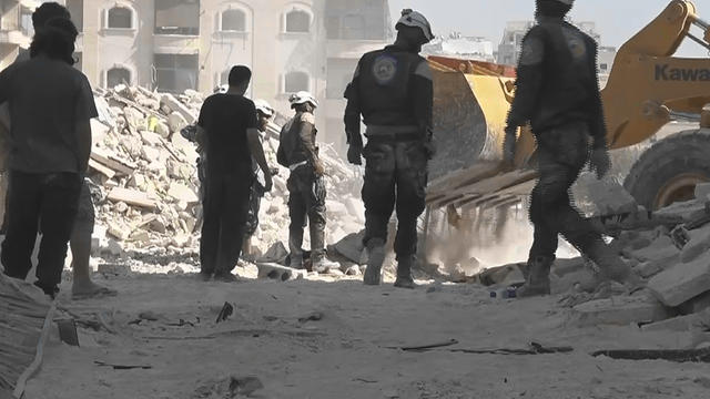 An images from the Syrian activist Thiqa Agency group shows civil defense rescue workers at the scene of an alleged airstrike on a women and children's hospital in the rebel-held town of Kafr Hamra, in northern Aleppo 