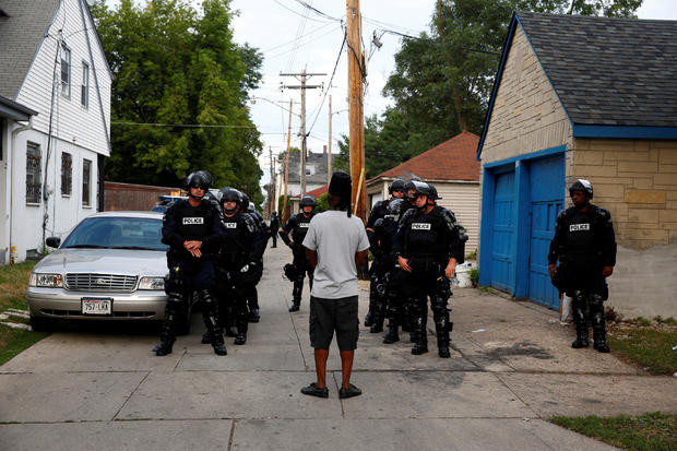 Police in riot gear assemble in an alley after disturbances following the police shooting of a man in Milwaukee, Wisconsin, Aug. 15, 2016. 