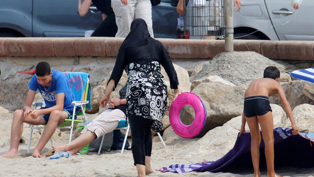 A Muslim woman wears a burkini, a swimsuit that leaves only the face, hands and feet exposed, on a beach in Marseille, France, Aug. 17, 2016. 