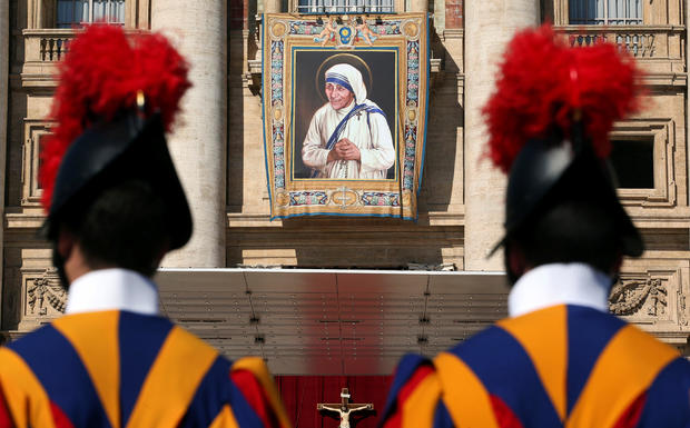 Swiss Guards stand in front of a tapestry depicting Mother Teresa of Calcutta before a mass, celebrated by Pope Francis, for her canonisation in Saint Peter’s Square 