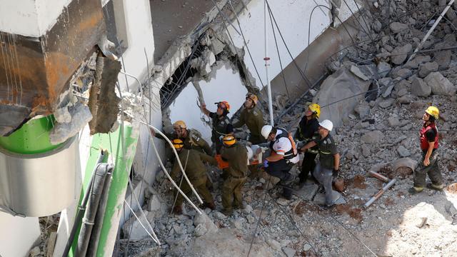Israeli medics and emergency units carry a wounded person away on a stretcher from a construction site after an underground car park collapsed 