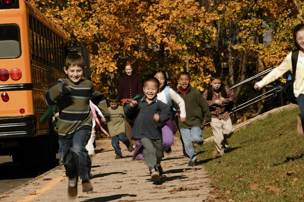 Children running after getting off school bus 