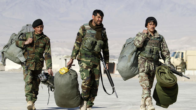 Afghan National Army soldiers carry their belongings at a military airport in Uruzgan province 