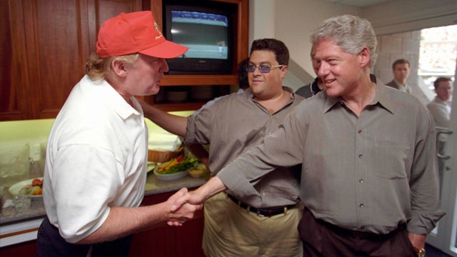 Donald Trump greets President Clinton at the U.S. Open in Flushing, New York, in this Sept. 8, 2000, handout photo. 